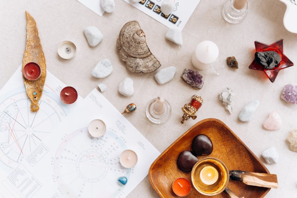 white-and-brown-stone-on-white-printer-paper-6932084 Flat lay of spiritual items including candles, crystals, and astrology charts for meditation.